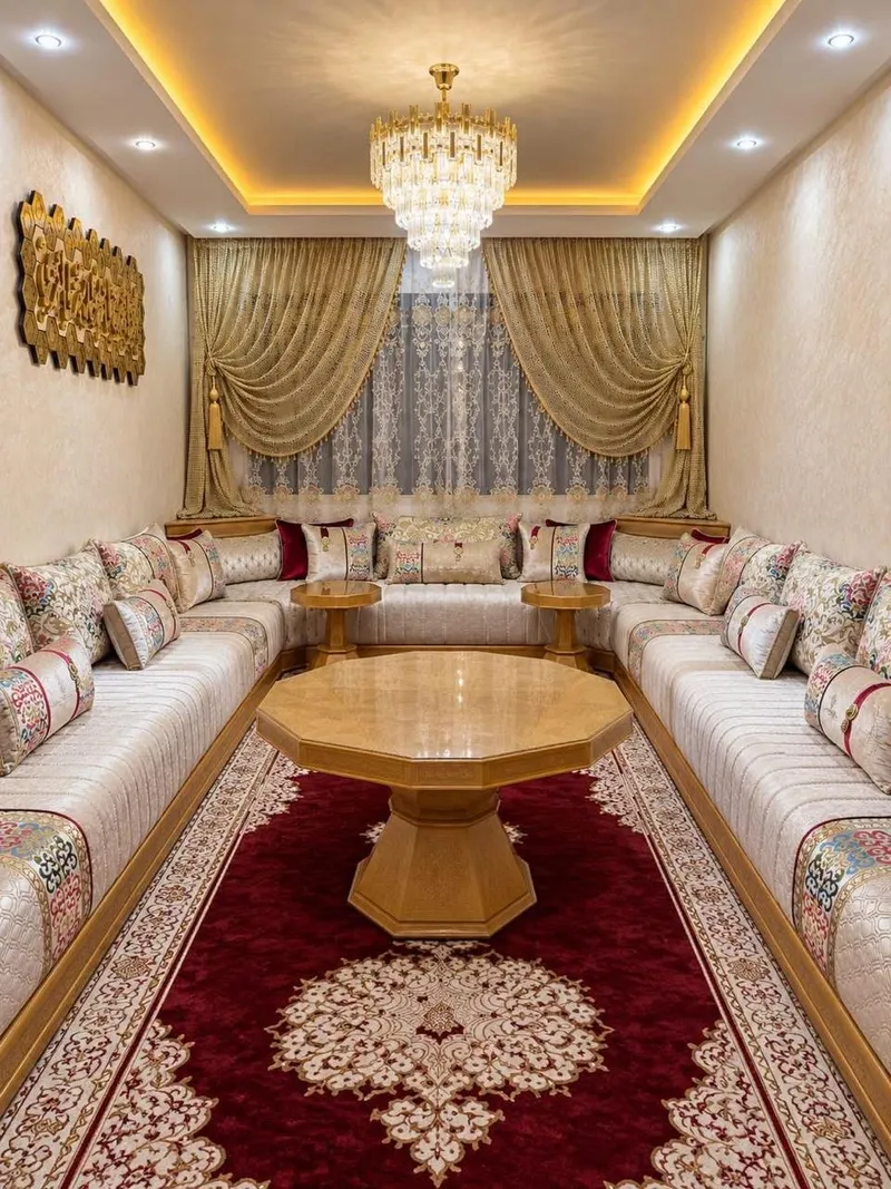 صالون مغربي كريمي على شكل U مع طاولة خشبية مثمنة وزربية حمراء