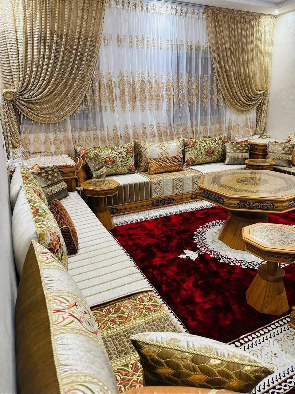 صالون مغربي كريمي بوسائد مطرزة زيتية وطاولات خشبية مثمنة