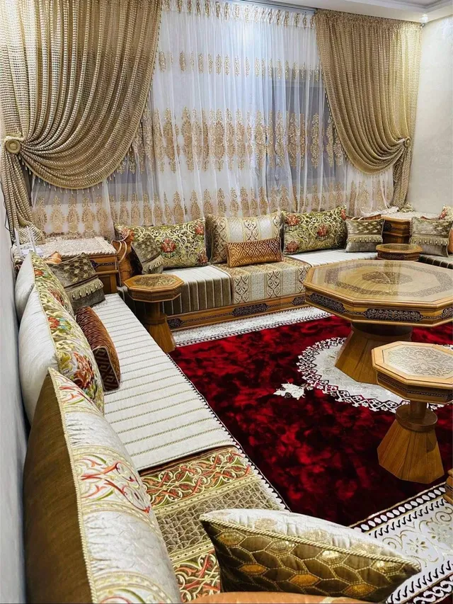 صالون مغربي كريمي بوسائد مطرزة زيتية وطاولات خشبية مثمنة