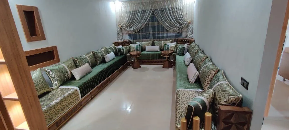 صالون مغربي أخضر طويل على شكل U بزخرفة هندسية