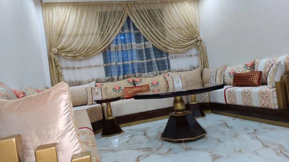 صالون مغربي كريمي بوسائد وردية وطاولة منخفضة