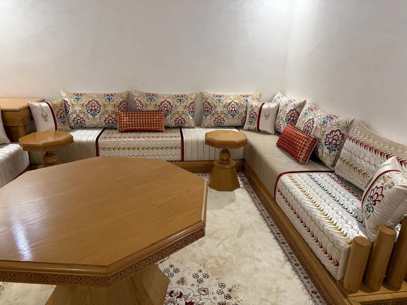 صالون مغربي كريمي بالورود مع طاولة خشبية مثمنة