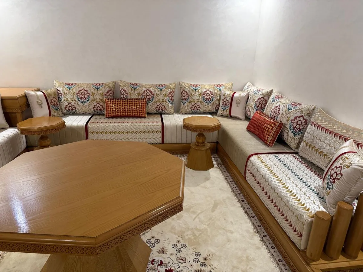 صالون مغربي كريمي بالورود مع طاولة خشبية مثمنة